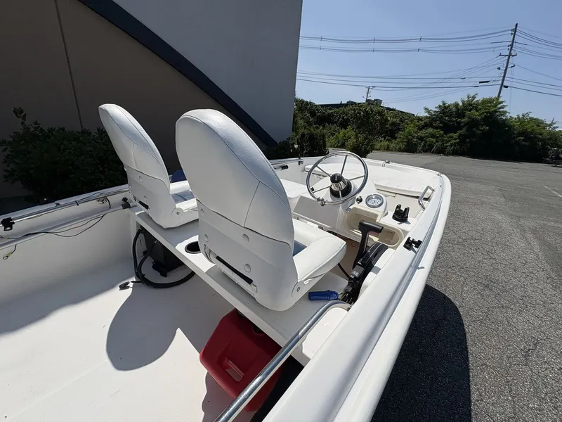 Slide: The Image of The image shows a 2009 Boston Whaler 130 Super Sport boat with two white seats. - 5