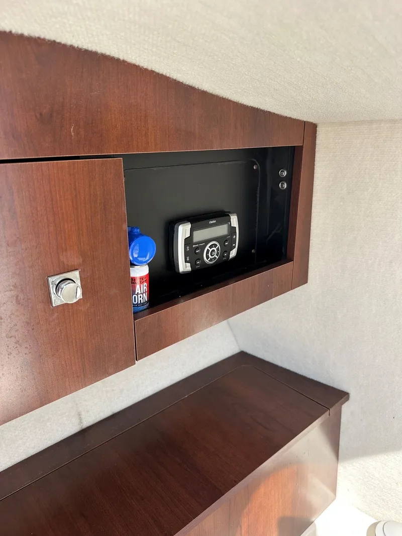 Slide: The Image of Interior of a Robalo R227 Dual Console with a wooden cabinet and built-in radio. - 22
