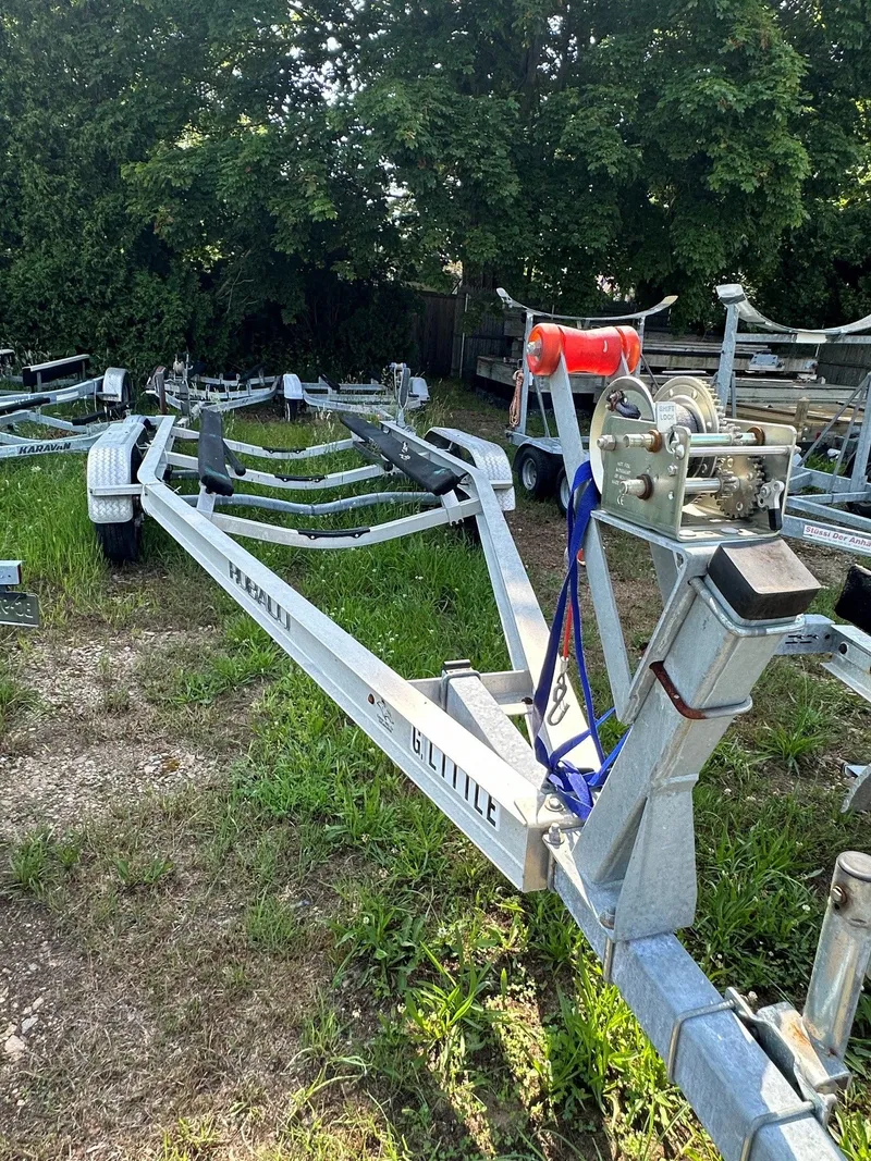 Slide: The Image of Boat trailer on grassy ground, surrounded by trees. - 29