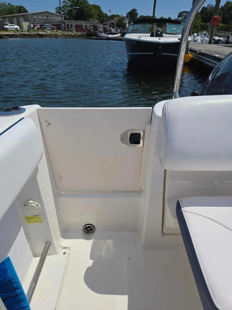 Slide: The Image of The image shows the cockpit of a 2018 Robalo R227 Dual Console boat at the dock. - 39