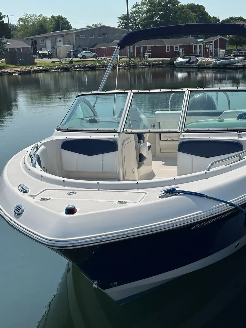 Slide: The Image of A 2018 Robalo R227 Dual Console boat is docked in a calm harbor. - 3