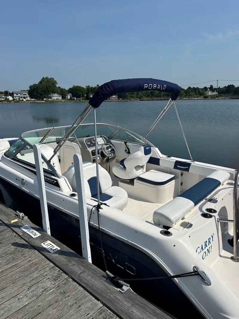 Slide: The Image of A 2018 Robalo R227 Dual Console boat docked at a calm pier. - 2