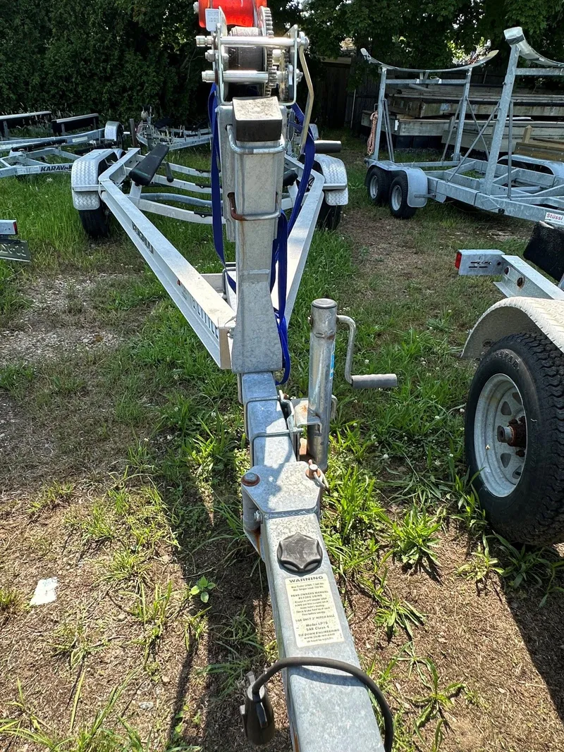 Slide: The Image of Boat trailer on grassy terrain with several trailers in the background. - 31