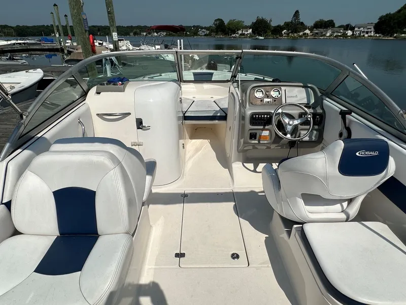 Slide: The Image of 2018 Robalo R227 Dual Console on calm water with a dock in the background. - 10