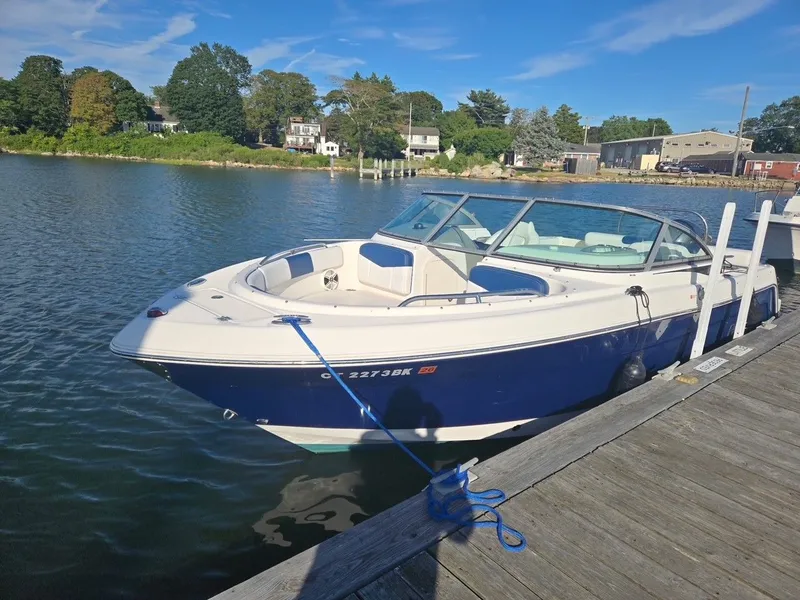 The Image of A 2018 Robalo R227 Dual Console boat docked at a wooden pier in a calm harbor. - 0
