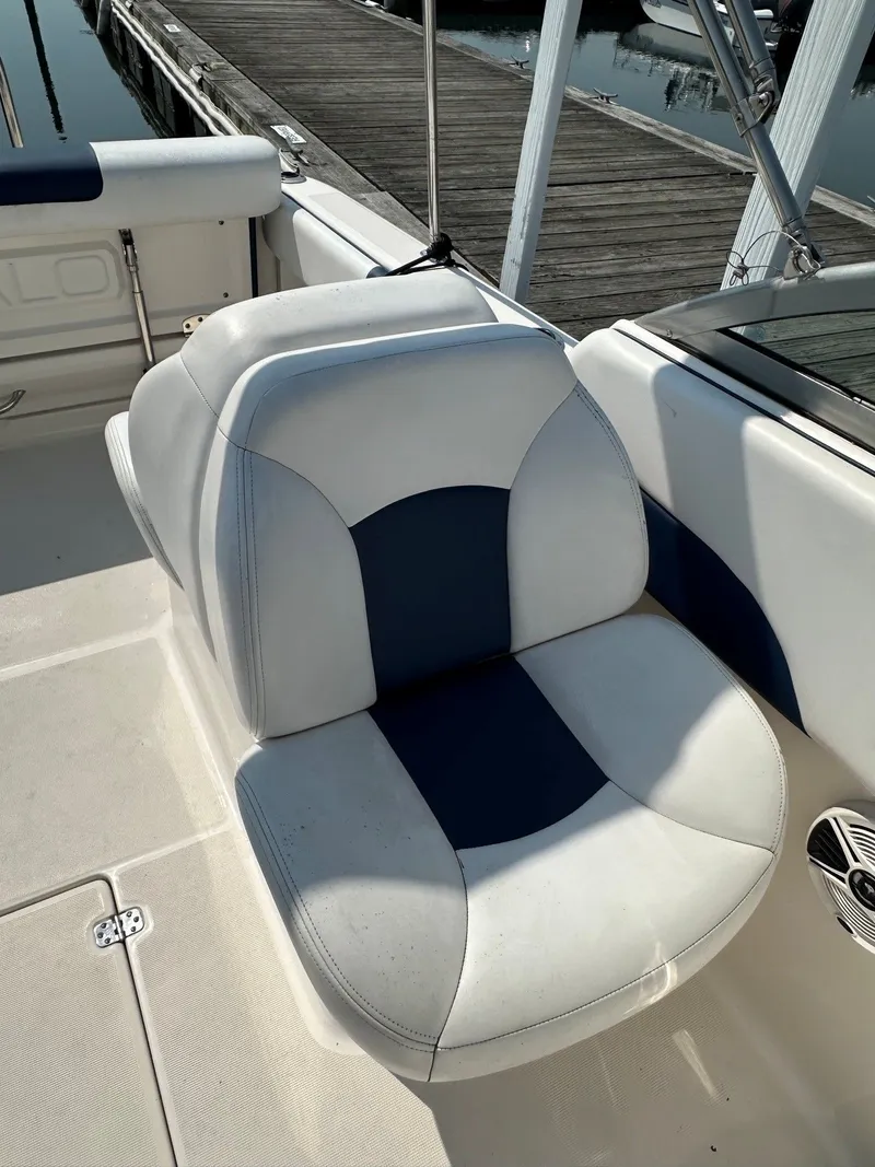 Slide: The Image of Seating area on a 2018 Robalo R227 Dual Console boat, featuring blue and white upholstery. - 14