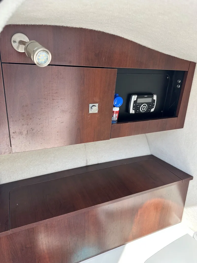 Slide: The Image of Interior view of a 2018 Robalo R227 Dual Console with wood paneling and storage space. - 23