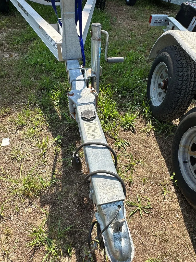 Slide: The Image of A boat trailer on grassy ground, featuring a sturdy metal frame and a wheel. - 30