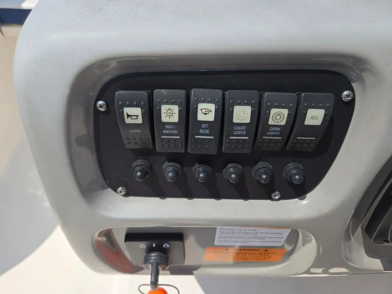 Slide: The Image of Control panel of a 2018 Robalo R227 Dual Console with various switches for boat controls. - 29