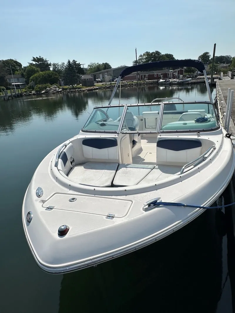 Slide: The Image of A white 2018 Robalo R227 Dual Console boat docked in calm waters. - 6