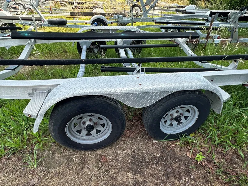 Slide: The Image of A boat trailer with two wheels is parked on grass. - 26