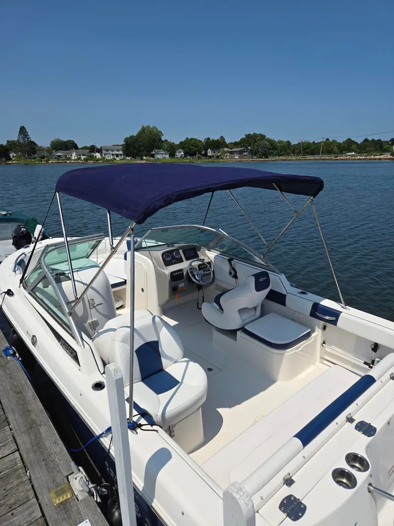 Slide: The Image of A 2018 Robalo R227 Dual Console boat docked. It features a blue sunshade. - 30