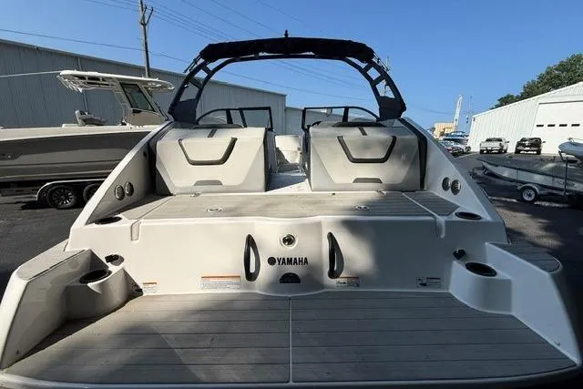 Slide: The Image of 2023 Yamaha Boats AR220, rear view, showcasing spacious deck and seating area. - 12