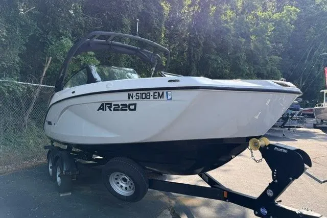 Slide: The Image of 2023 Yamaha Boats AR220 on trailer, parked outdoors, surrounded by trees. - 3