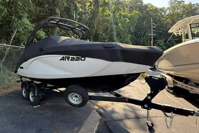 Slide: The Image of 2023 Yamaha Boats AR220 on trailer, parked outdoors near trees. - 13