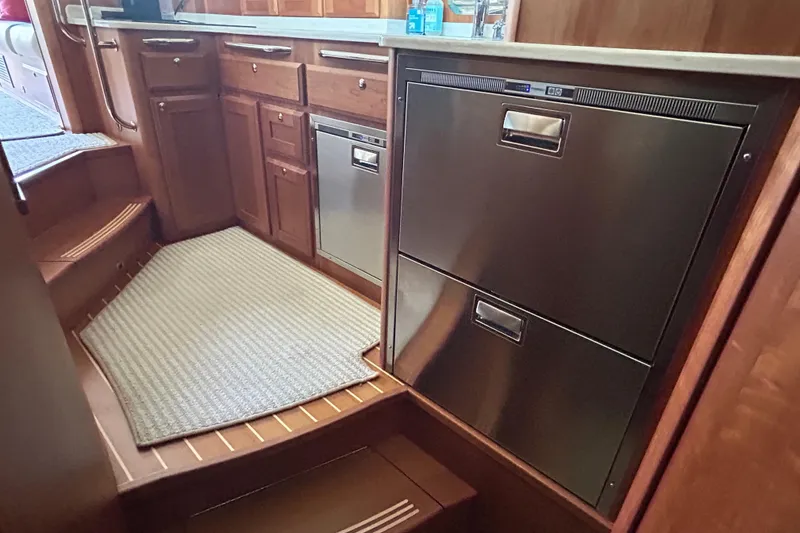Slide: The Image of 2022 Sabre 45 Salon Express galley with stainless steel appliances and wooden cabinetry. - 40