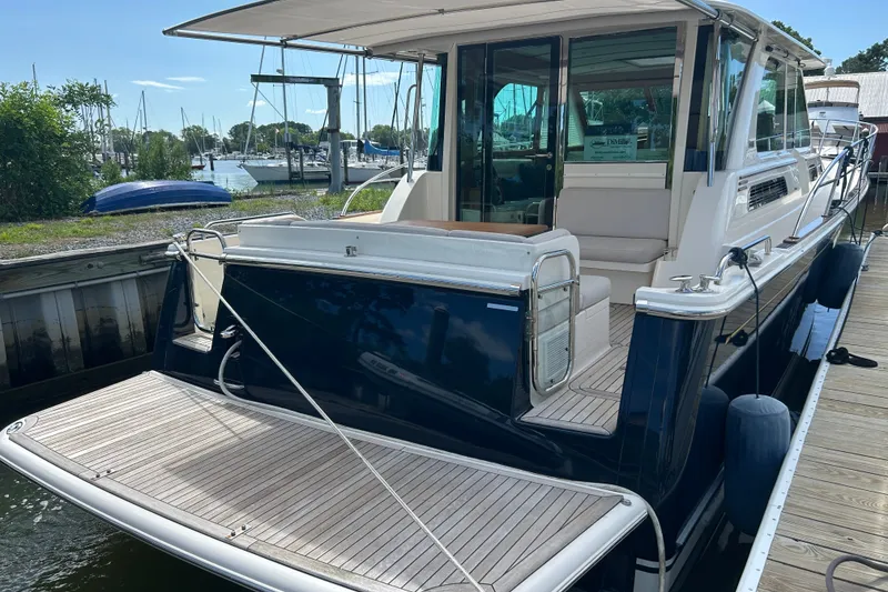 Slide: The Image of 2022 Sabre 45 Salon Express yacht docked, showcasing sleek design and spacious deck area. - 58