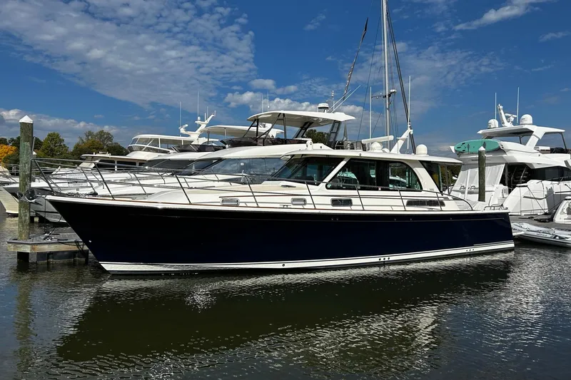 Slide: The Image of 2022 Sabre 45 Salon Express yacht docked at marina under blue sky. - 5