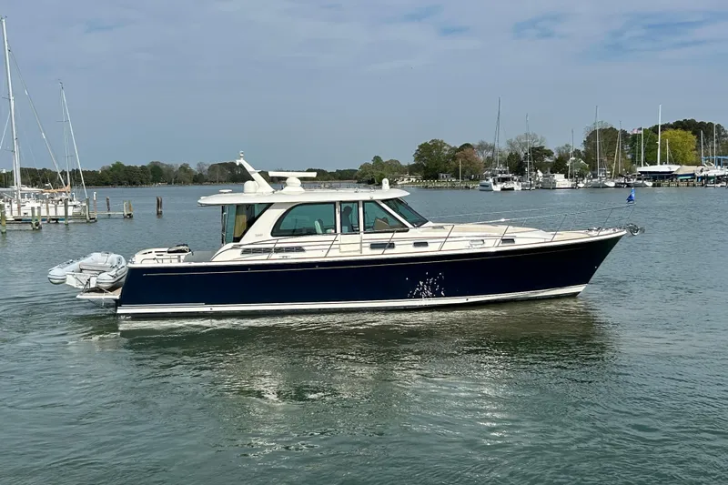 Slide: The Image of 2022 Sabre 45 Salon Express yacht cruising in a serene marina setting. - 4
