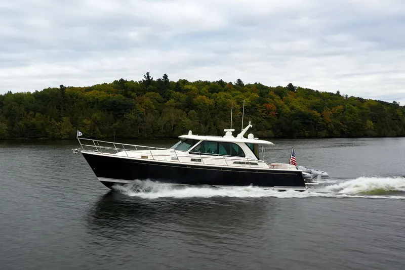 Slide: The Image of 2022 Sabre 45 Salon Express cruising on a scenic lake with lush green forest backdrop. - 6