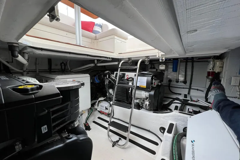 Slide: The Image of Engine room of 2022 Sabre 45 Salon Express yacht, showcasing mechanical components and seating area. - 51