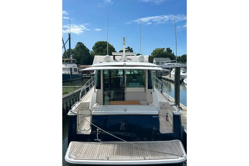 Slide: The Image of 2022 Sabre 45 Salon Express yacht docked at marina, rear view. - 2
