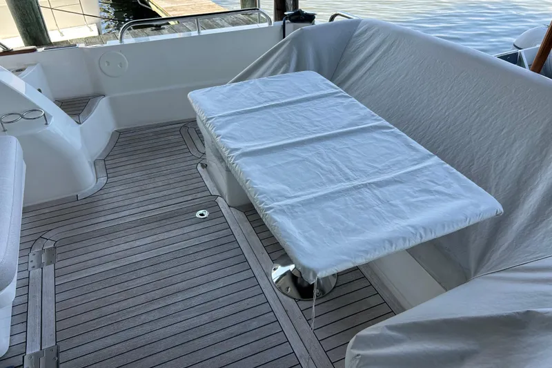 Slide: The Image of 2022 Sabre 45 Salon Express yacht deck with covered table and seating area. - 10