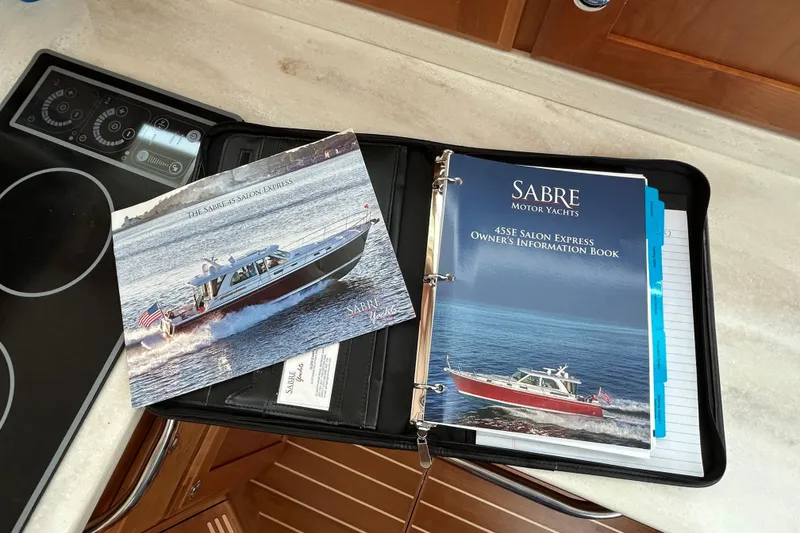 Slide: The Image of Binder with Sabre 45 Salon Express 2022 brochures on a yacht's kitchen counter. - 51
