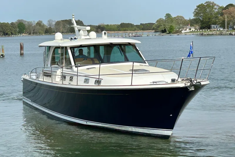 Slide: The Image of 2022 Sabre 45 Salon Express yacht cruising on a calm river. - 1