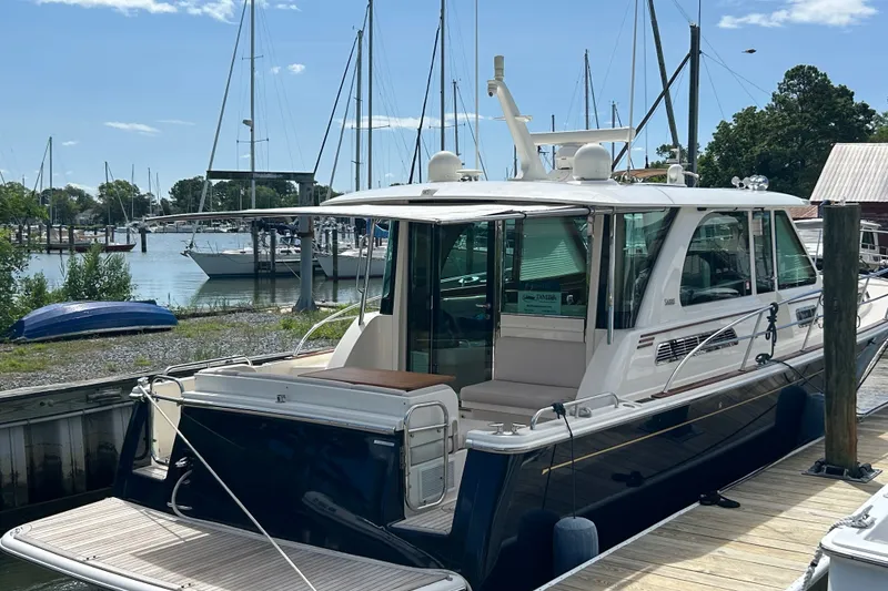 Slide: The Image of 2022 Sabre 45 Salon Express yacht docked at marina with sailboats in background. - 1