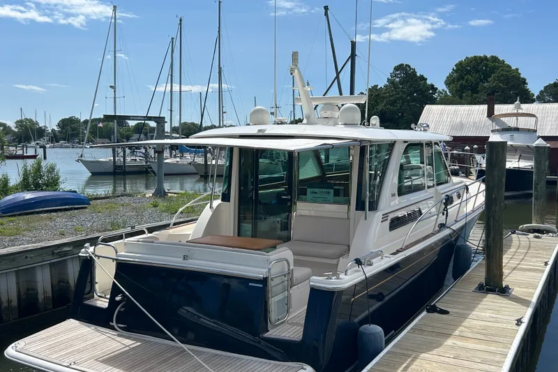Slide: The Image of 2022 Sabre 45 Salon Express yacht docked at a marina under a clear blue sky. - 59