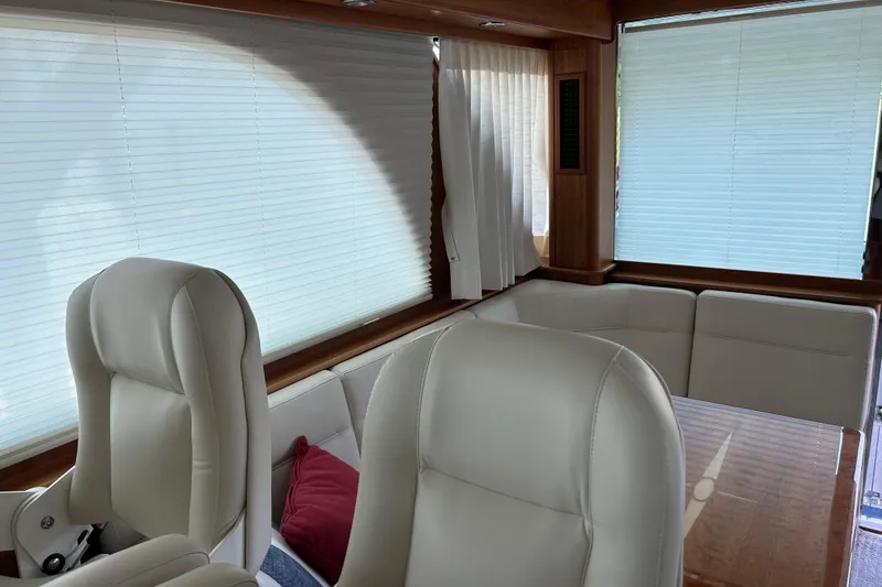 Slide: The Image of Interior of 2022 Sabre 45 Salon Express yacht with white leather seating and wooden accents. - 17