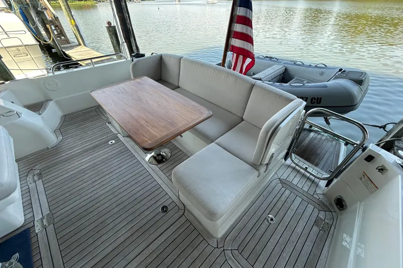 Slide: The Image of 2022 Sabre 45 Salon Express yacht deck with seating, table, and American flag. - 9