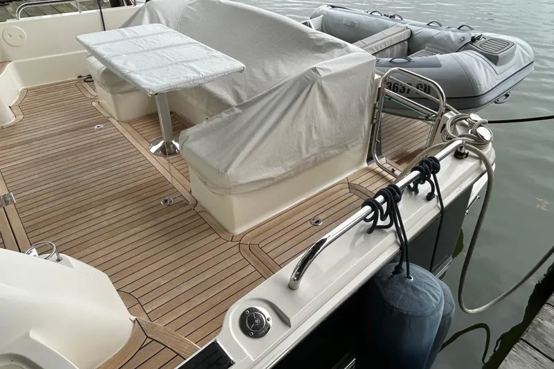 Slide: The Image of 2022 Sabre 45 Salon Express yacht deck with covered seating and inflatable boat. - 53