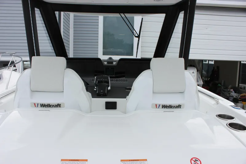 Slide: The Image of 2027 Wellcraft 28 T-Top boat interior with dual white seats and control panel. - 26