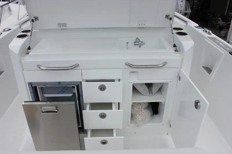 Slide: The Image of 2027 Wellcraft 28 T-Top boat interior with sink, storage drawers, and cabinets. - 20