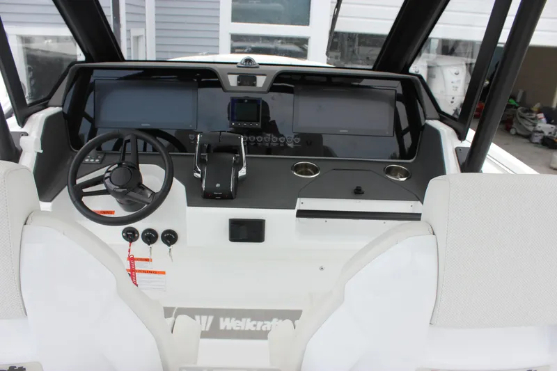 Slide: The Image of 2027 Wellcraft 28 T-Top boat dashboard with steering wheel and modern controls. - 25