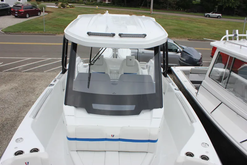Slide: The Image of 2027 Wellcraft 28 T-Top boat with sleek design, docked in a marina setting. - 49