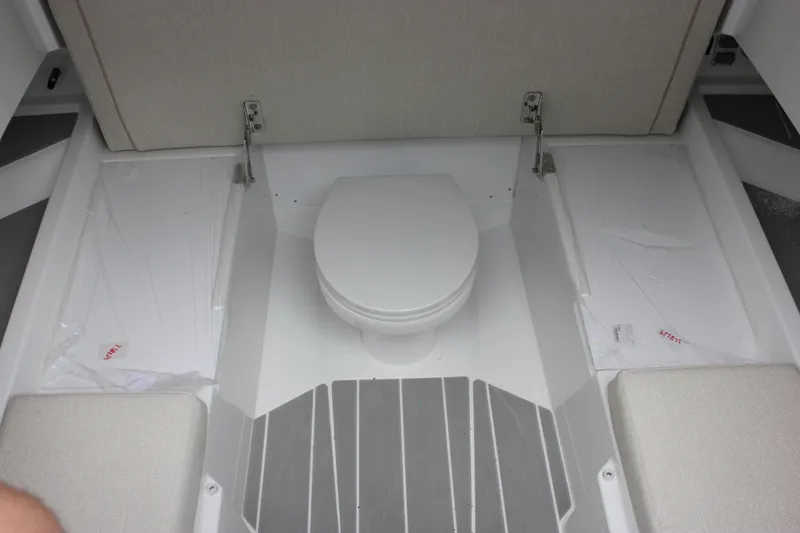 Slide: The Image of Interior of 2027 Wellcraft 28 T-Top boat featuring a compact marine toilet. - 59
