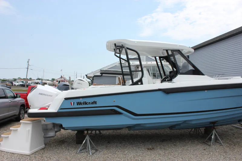 Slide: The Image of 2027 Wellcraft 28 T-Top boat in a marina, featuring sleek design and Mercury engine. - 4