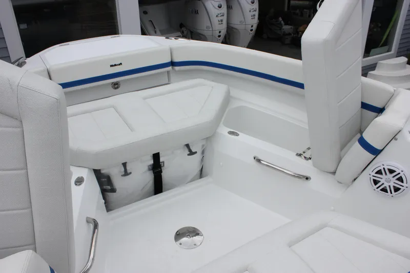Slide: The Image of Interior view of 2027 Wellcraft 28 T-Top boat with white seating and blue accents. - 42
