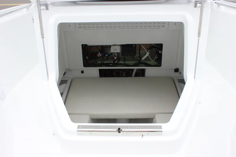 Slide: The Image of 2027 Wellcraft 28 T-Top boat interior storage compartment with visible wiring and cushion. - 57