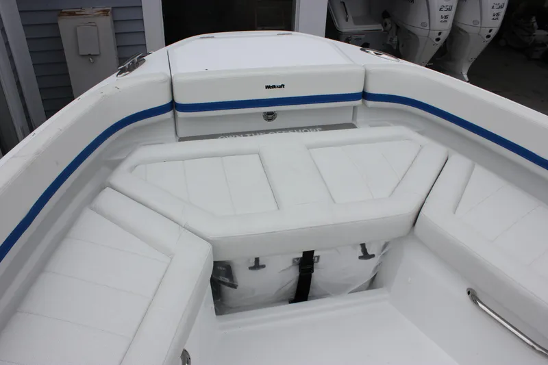 Slide: The Image of Interior view of 2027 Wellcraft 28 T-Top boat with white seating and blue accents. - 40