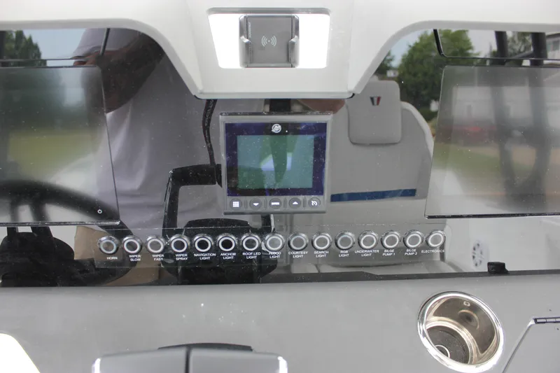 Slide: The Image of Control panel of a 2027 Wellcraft 28 T-Top boat with various switches and a display. - 35