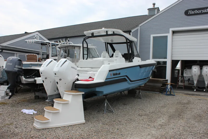 Slide: The Image of 2027 Wellcraft 28 T-Top boat with twin Mercury engines at a marina. - 3