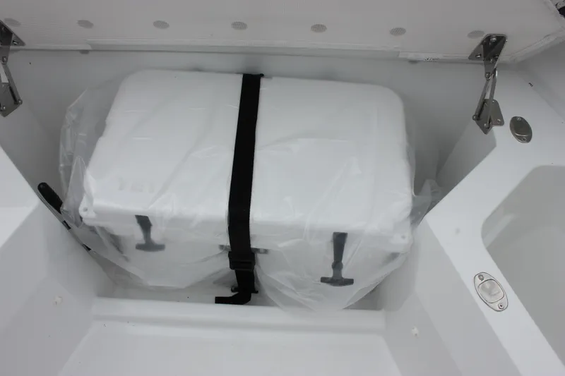 Slide: The Image of 2027 Wellcraft 28 T-Top boat storage compartment with secured white cooler. - 41