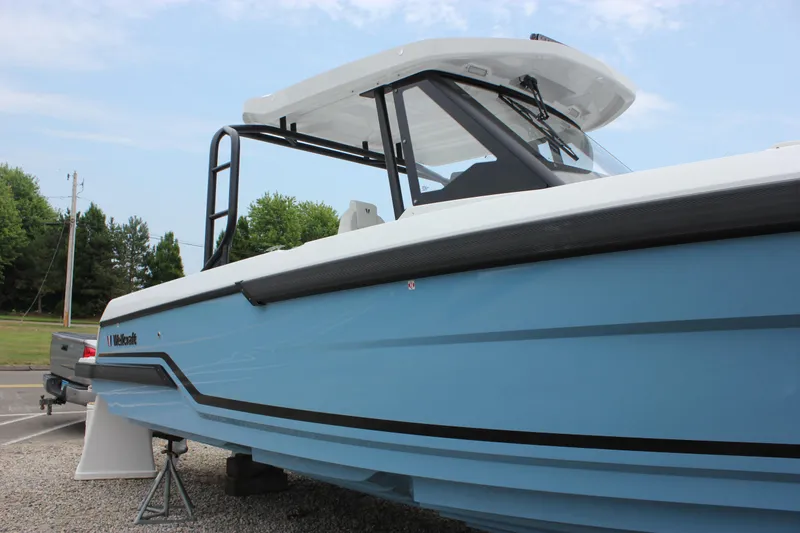 Slide: The Image of 2027 Wellcraft 28 T-Top boat in light blue, parked on gravel, side view. - 6