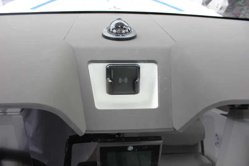Slide: The Image of Dashboard of 2027 Wellcraft 28 T-Top boat featuring a compass and electronic device. - 34