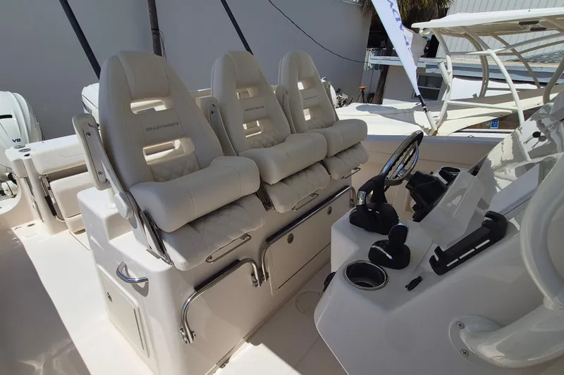 Slide: The Image of Three luxurious, cushioned seats on a modern boat with a steering console and wheel. - 12