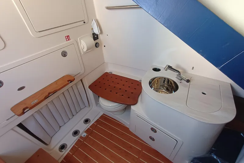 Slide: The Image of Interior of a Grady-White Canyon 336 with sink, toilet, and wooden flooring. - 18
